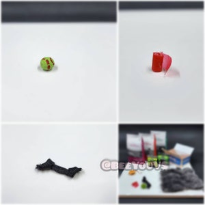 Puede incluir: Primer plano de una pelota verde y roja, un trozo de tela roja enrollado, una cuerda negra y un objeto peludo gris. Tambi&eacute;n hay otros objetos en el fondo, incluyendo una caja con el texto "BEEYOUS" en ella.