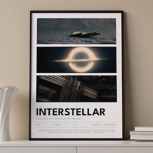 May include: A framed poster for the film "Interstellar" with a black frame. The poster features three images: a spacecraft in water, a black hole, and an abstract structure. The title "Interstellar" is displayed in bold white text.