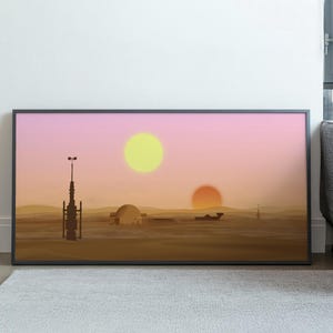 May include: A framed art print showing a desert scene with two suns, in a style reminiscent of science fiction. The artwork uses a warm colour palette of oranges, yellows, and pinks, with stylised structures and silhouettes.