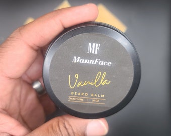 May include: A black tin container with a gold label that reads "MF MannFace Vanilla Beard Balm Cruelty Free | 20 oz."
