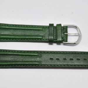May include: A dark green leather watch strap with a silver buckle. The strap has a textured surface and is stitched with white thread.