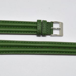 May include: A green leather watch strap with a silver buckle. The strap has a textured design and is stitched with white thread.