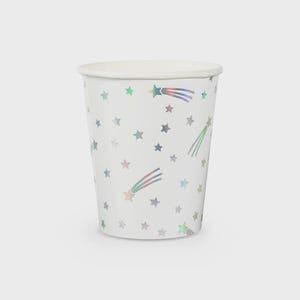 May include: White paper cup with a repeating pattern of holographic stars and shooting stars. The cup has a rolled rim and is designed for beverages. Ideal for parties and celebrations.