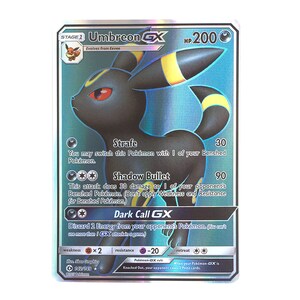 May include: A Umbreon GX Pokemon card from the Sun & Moon expansion. The card features a blue and black Umbreon with yellow accents. The card has a HP of 200 and has three attacks: Strafe, Shadow Bullet, and Dark Call GX.