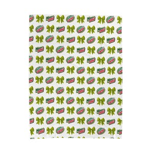 Può includere: Tessuto bianco con un motivo ripetuto di fiocchi verdi e il logo "Mountain Dew". I fiocchi sono di un verde brillante, e il logo è rosso, bianco e verde. Il design è giocoso e festoso.