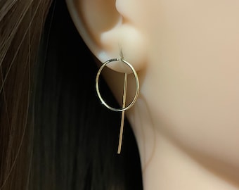 以下が含まれることがあります： フープ型の金色のイヤリング。フープの下から細い棒がぶら下がっている。
