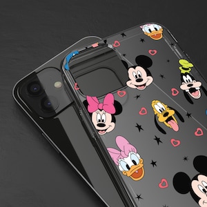 Peut inclure: Une coque de téléphone transparente avec un fond noir et des personnages de dessins animés colorés de Disney. Les personnages incluent Mickey Mouse, Minnie Mouse, Donald Duck, Dingo et Pluto. La coque a un fond noir avec des étoiles blanches et des cœurs rouges.