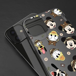 Puede incluir: Una funda transparente para teléfono con un patrón de personajes de Disney con atuendos de safari. Los personajes incluyen Mickey Mouse, Minnie Mouse, Donald Duck, Goofy y Pluto. La funda está diseñada para un teléfono inteligente con una lente de cámara en la parte posterior.