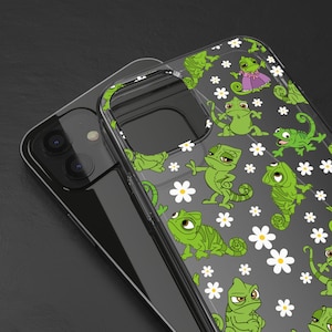 Puede incluir: Una funda transparente para teléfono con un patrón de camaleones verdes y margaritas blancas. La funda está diseñada para un teléfono inteligente con una lente de cámara dual.