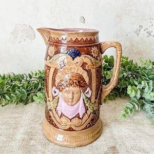 Pichet ancien en majolique avec visage figuratif
