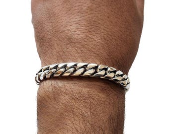 May include: A silver curb chain bracelet with a thick, chunky design.