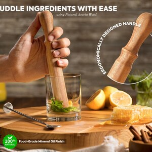 K&ouml;nnte beinhalten: Ein Holzst&ouml;&szlig;el mit einem Griff aus nat&uuml;rlichem Akazienholz. Der St&ouml;&szlig;el wird verwendet, um Zutaten in einem Glas zu zerdr&uuml;cken. Der Text "ERGONOMICALLY DESIGNED HANDLE" ist auf dem Bild sichtbar. Der Text "MUDDLE INGREDIENTS WITH EASE using Natural Acacia Wood" ist ebenfalls auf dem Bild sichtbar. Der Text "100% NATURAL" und "Food-Grade Mineral Oil Finish" ist ebenfalls auf dem Bild sichtbar.
