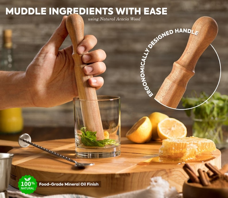 K&ouml;nnte beinhalten: Ein Holzst&ouml;&szlig;el mit einem Griff aus nat&uuml;rlichem Akazienholz. Der St&ouml;&szlig;el wird verwendet, um Zutaten in einem Glas zu zerdr&uuml;cken. Der Text "ERGONOMICALLY DESIGNED HANDLE" ist auf dem Bild sichtbar. Der Text "MUDDLE INGREDIENTS WITH EASE using Natural Acacia Wood" ist ebenfalls auf dem Bild sichtbar. Der Text "100% NATURAL" und "Food-Grade Mineral Oil Finish" ist ebenfalls auf dem Bild sichtbar.