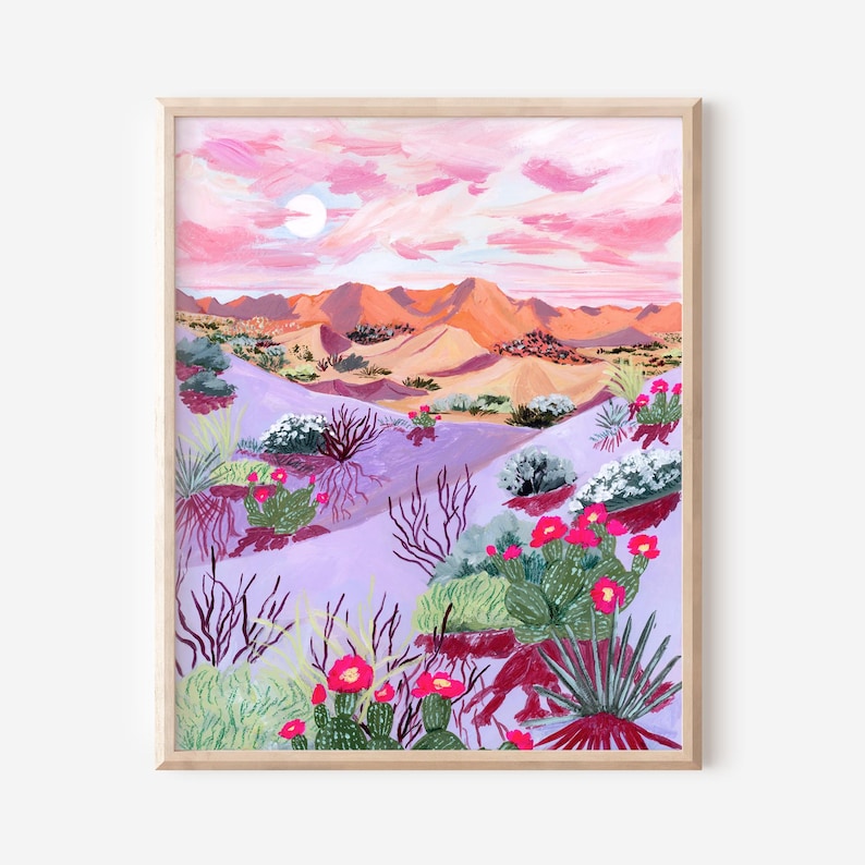 May include: A framed painting of a desert landscape. The artwork depicts a pink and orange sunset over rolling hills and a desert floor with cacti and wildflowers. The colour palette includes pink, purple, green, and orange.