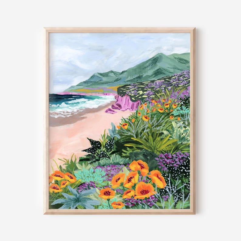 K&ouml;nnte beinhalten: Gerahmter Kunstdruck einer K&uuml;stenlandschaft. Das Kunstwerk zeigt einen Strand mit Wellen, einen Sandstrand und gr&uuml;ne Berge im Hintergrund. Der Vordergrund zeigt leuchtend orange und violette Blumen.