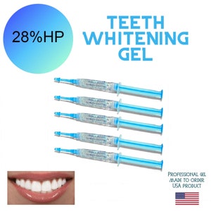 May include: Five clear syringes filled with a blue gel, labeled "Teeth Whitening Gel". The syringes are arranged vertically, with the tips pointing to the right. The text "28% HP" is visible in a blue circle at the top left of the image. A close-up of a person's white teeth is visible at the bottom left of the image. The text "Professional Gel Made to Order USA Product" is visible at the bottom right of the image, along with a small American flag.