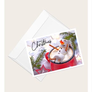 Marshmallow-sneeuwpop drijvend in warme chocolademelk Wenskaart "Merry Christmas" | Humoristische kerstkaart | Blanco kaart