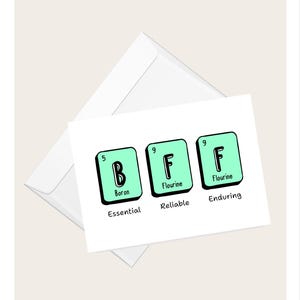 Può includere: Un biglietto di auguri bianco con le lettere "BFF" in stile tavola periodica. Ogni lettera è in un quadrato verde acqua con il nome dell'elemento e un descrittore: Boro/Essenziale, Fluoro/Affidabile e Fluoro/Duraturo. Una busta è sullo sfondo.