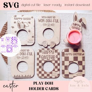 May include: Wooden Easter-themed Play-Doh holder cards with various designs, including bunny ears, paw prints, and checkered patterns. The cards feature the phrases "Happy Easter" and "You are so Won-Doh-Ful." A small pink Play-Doh container is also visible.