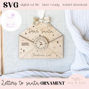 May include: Wooden Christmas ornament shaped like an envelope, with the text "Dear Santa" and "Christmas List". Features a "North Pole Express Mail" emblem and decorative stars. Includes a ribbon and bow for hanging. The words "SVG digital cut file laser ready instant download" are at the top.