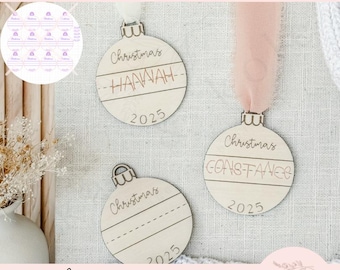 Puede incluir: Adornos navideños de madera con los nombres "Hannah" y "Constance" grabados, junto con el año 2025. Los adornos tienen un estilo manuscrito y están colgados con cintas. La imagen también incluye el texto "Handwriting ORNAMENTS".