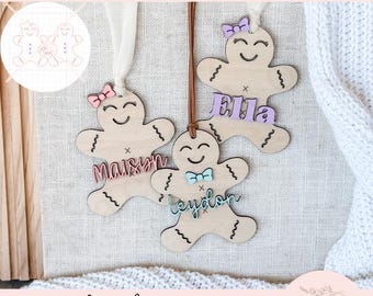 May include: Wooden gingerbread ornaments with personalized names and decorative bows. Each ornament is laser-cut with a smiling face and wavy arms and legs. The names are in pastel colors. The text "SVG digital cut file laser ready instant download" is at the top.