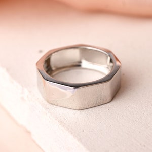 May include: A silver hexagonal ring with a polished finish.