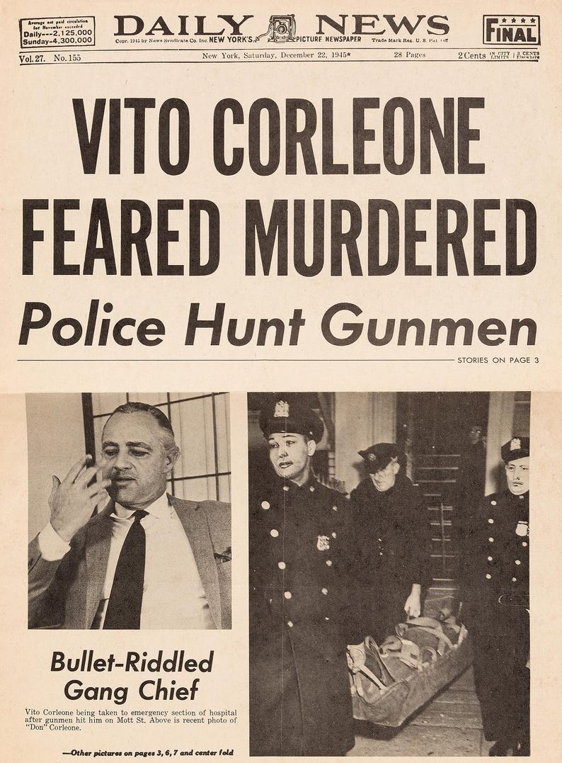 May include: A black and white newspaper headline reads "VITO CORLEONE FEARED MURDERED" with the subheading "Police Hunt Gunmen". The newspaper is dated December 22, 1945. A black and white photo of a man in a suit is shown in the upper left corner of the newspaper. A black and white photo of a man in a police uniform is shown in the upper right corner of the newspaper. A black and white photo of a group of police officers carrying a stretcher is shown in the lower right corner of the newspaper.