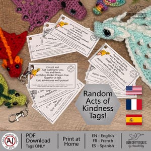 May include: A collection of handmade crochet dragon toys and tags. The dragons are in various colors, including red, green, and purple. The tags have text in English, French, and Spanish, and are labeled "Random Acts of Kindness Tags!"