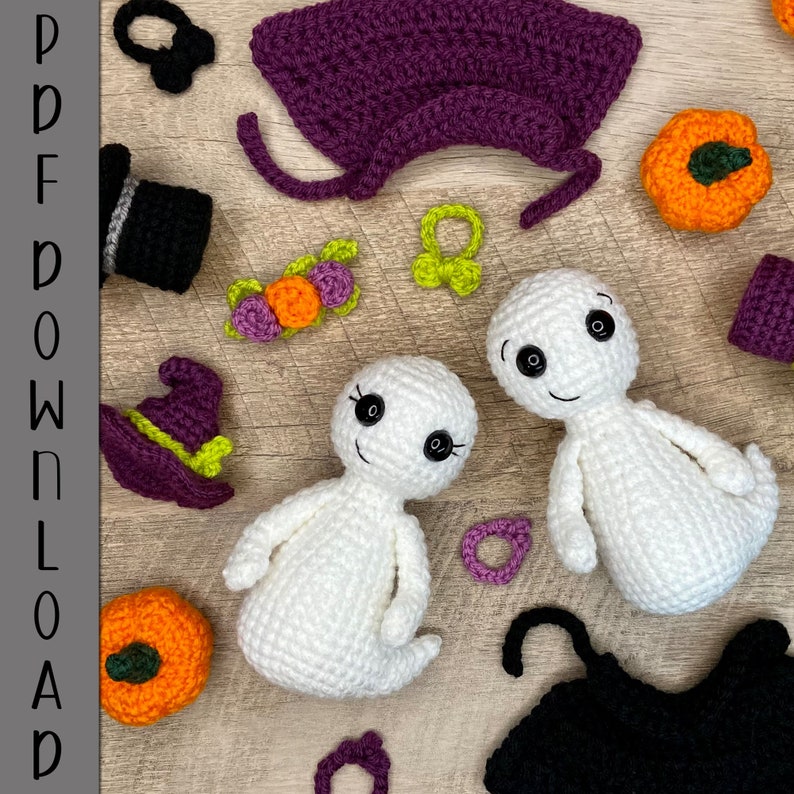 May include: Crochet ghost amigurumi pattern with a purple witch hat, a black witch hat, a green and purple flower garland, a purple cape, and two orange pumpkins.