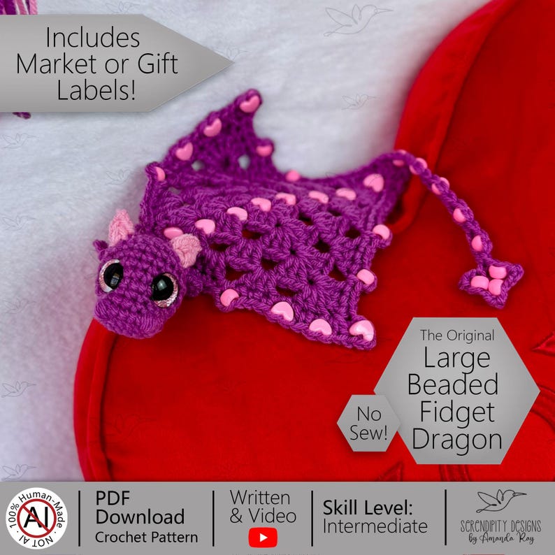 May include: A handmade purple crochet dragon with pink heart accents and large black eyes. The dragon has a long tail and is labeled "The Original Large Beaded Fidget Dragon". The image also includes the text "No Sew!" and "PDF Download Crochet Pattern".