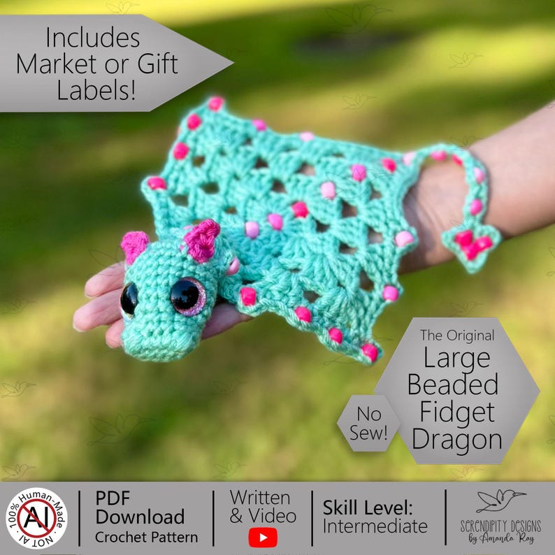 May include: A turquoise crocheted dragon with pink accents and large black eyes. The dragon has a beaded body and a long tail. The image includes text that says "The Original Large Beaded Fidget Dragon" and "No Sew!"
