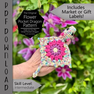 May include: A crocheted flower pocket dragon pattern in pink, purple, and yellow. The dragon has a flower-shaped body and a dragon head. The image includes text that says "The Original Flower Pocket Dragon Pattern" and "Skill Level: Intermediate."