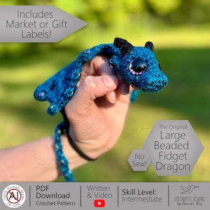 May include: A handmade blue crochet dragon with black accents and large, purple-rimmed eyes. The dragon is labeled "The Original Large Beaded Fidget Dragon" and is designed with an intermediate skill level. The image also includes text that says "No Sew!"