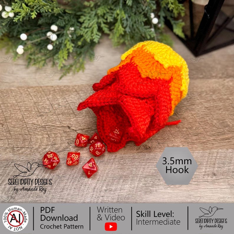 May include: A crochet dice bag featuring a gradient of yellow, orange, and red yarn, shaped like a flame. Several red polyhedral dice with gold numbers are scattered in front of the bag. Text on the image indicates a 3.5mm hook requirement.