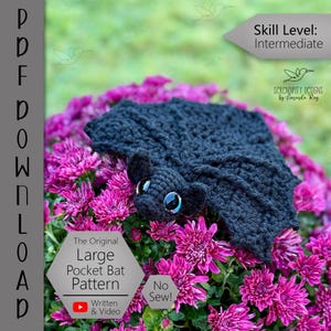 Puede incluir: Un murci&eacute;lago negro tejido a ganchillo con ojos grandes, sobre flores rosas brillantes. La imagen anuncia un "Large Pocket Bat Pattern" con instrucciones en v&iacute;deo y "No Sew!". Nivel de habilidad: Intermedio.