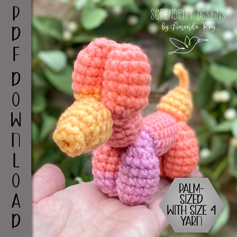 May include: A crocheted, palm-sized, multi-coloured figure in shades of orange, pink, and yellow. The figure is made with size 4 yarn. The image includes the text "PDF DOWNLOAD" and "PALM-SIZED WITH SIZE 4 YARN". The design is by Amanda Ray.