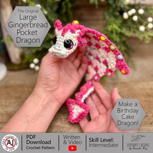 Könnte beinhalten: Ein handgehäkelter Drache in Rosa, Weiß und Gelb, mit dem Text "The Original Large Gingerbread Pocket Dragon". Der Drache wird in Händen gehalten. Der Text "Make a Birthday Cake Dragon!" ist ebenfalls sichtbar. Mittleres Fähigkeitsniveau.
