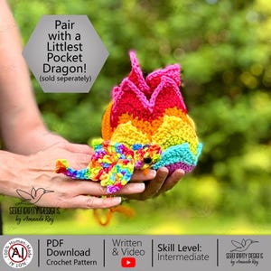May include: A multi-colored crocheted dragon toy featuring a rainbow-patterned body with a jagged, red-topped spine. The text on the image reads: Pair with a Littlest Pocket Dragon! (sold seperately), Serendipity Designs by Amanda Ray, PDF Download Crochet Pattern, Written & Video, Skill Level: Intermediate.