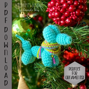 May include: A turquoise crocheted dachshund ornament with a pink and green striped scarf hanging on a Christmas tree. The text "PERFECT FOR ORNAMENTS!" is visible in the image.