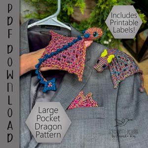 May include: A crocheted dragon pattern with a multi-colored body, blue accents, and a star-shaped charm. The dragon is displayed on a gray blazer, with a matching pocket square and a smaller dragon. The image includes the text "Large Pocket Dragon Pattern".
