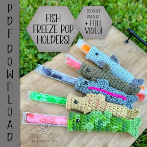 May include: Crochet pattern for fish-shaped popsicle holders. The pattern includes a full video tutorial. The image shows six crocheted fish in different colors, each holding a popsicle.