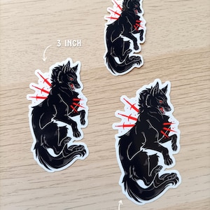Puede incluir: Tres pegatinas de lobo negro con detalles en rojo y un dise&ntilde;o de explosi&oacute;n. Las pegatinas miden 5,08, 7,62 y 8,89 cm de alto. El lobo tiene ojos rojos y est&aacute; en una pose din&aacute;mica, con una textura de pelaje detallada.