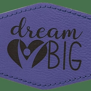 May include: Purple leather patch with a black heart and the text "dream BIG" in a handwritten font.