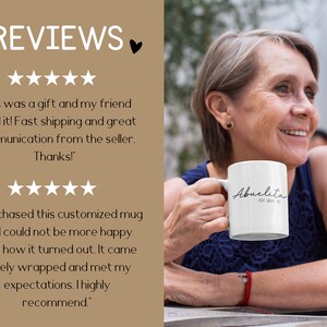 May include: A white ceramic mug with the text "Abuelita EST 2021" in black script. A person is holding the mug and smiling.