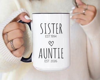 May include: White ceramic mug with black text that reads "Sister Est. 1994" with a heart symbol and "Auntie Est. 2026".