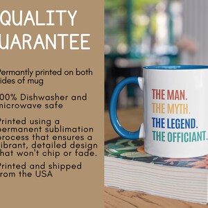 K&ouml;nnte beinhalten: Eine wei&szlig;e Keramik-Kaffeetasse mit blauem Henkel. Die Tasse hat ein farbenfrohes Design mit dem Text "THE MAN. THE MYTH. THE LEGEND. THE OFFICIANT."