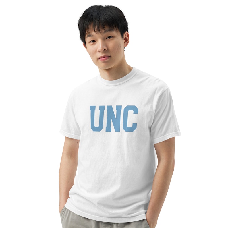Op de afbeelding: Een wit T-shirt met een blauwe "UNC" print op de voorkant.