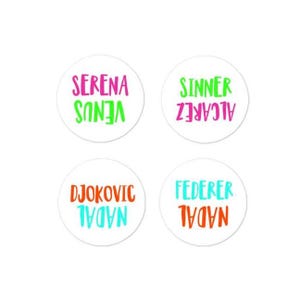 Può includere: Quattro adesivi rotondi bianchi con testo colorato. Gli adesivi mostrano i nomi di famosi giocatori di tennis: Serena Venus, Alcaraz Sinner, Nadal Djokovic e Nadal Federer.