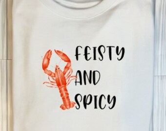 May include: White t-shirt with a red lobster illustration and the text "Feisty and Spicy" printed in black.